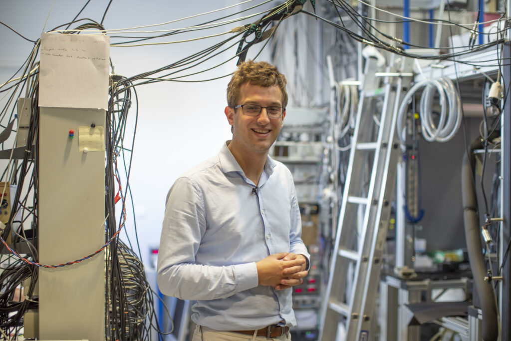 Portrait de Gautier Depambour devant des cables du Laboratoire Kastler-Brossel.