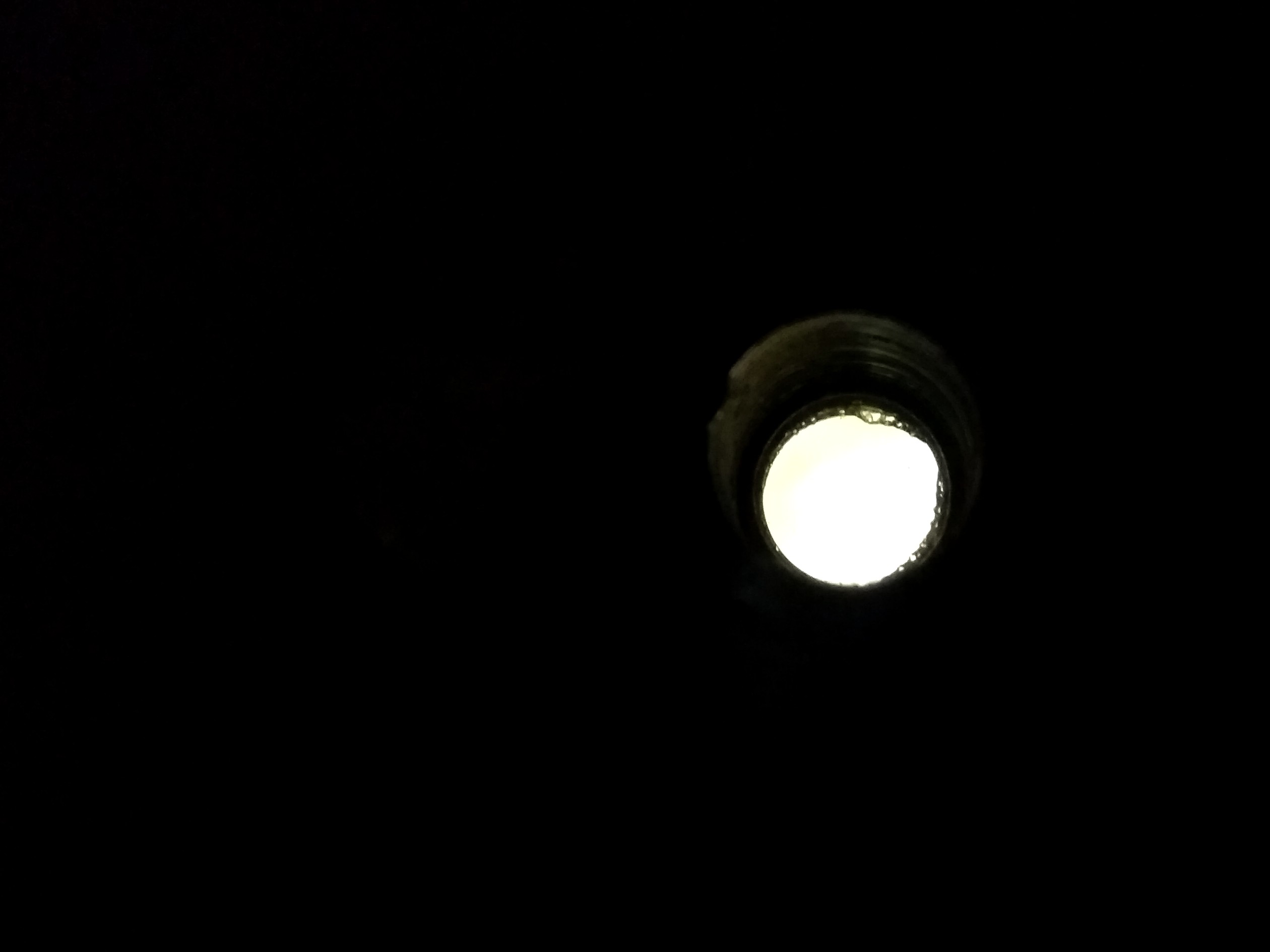 Photo d'un judas de porte : la lumière provient de l'extérieur.