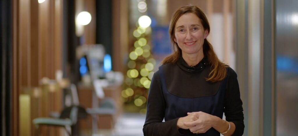 Portait photographique de Stéphanie Bioulac, devant un fnd flouté contenant un sapin de Noël