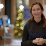 Portait photographique de Stéphanie Bioulac, devant un fond flouté contenant un sapin de Noël