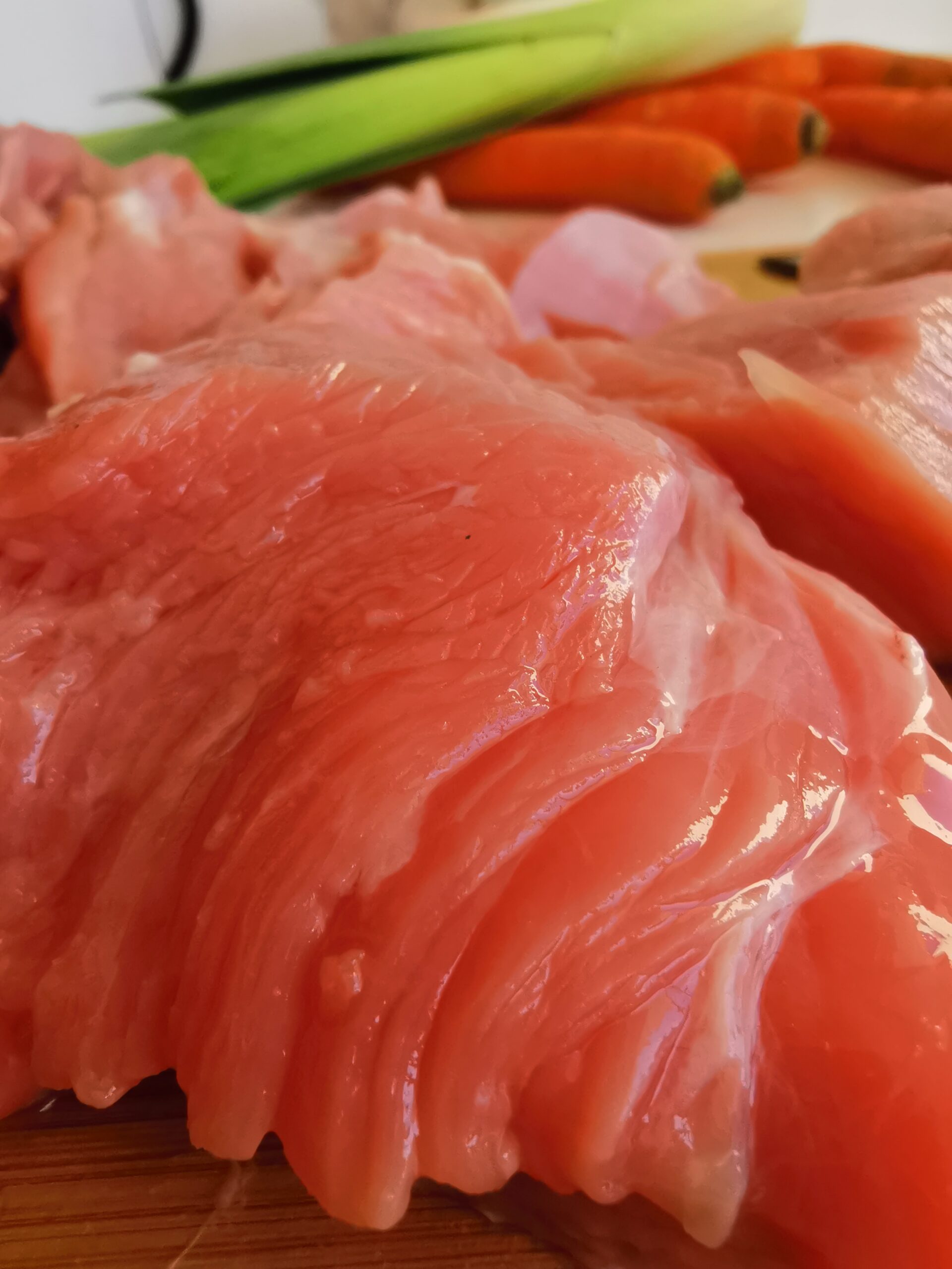 Viande de veau en premier plan avec des légumes en arrière plan