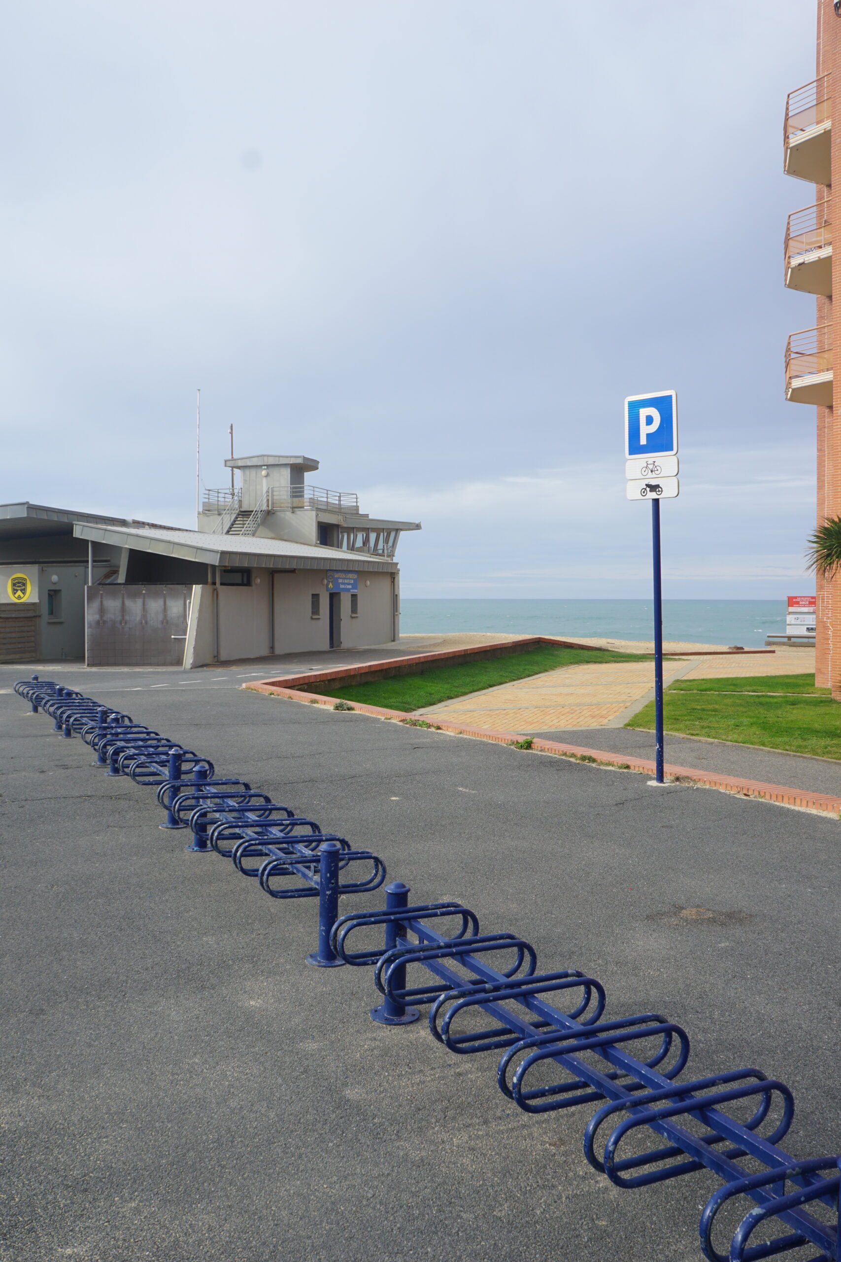 Photographie d'un parc à vélo vide en bord de mer.