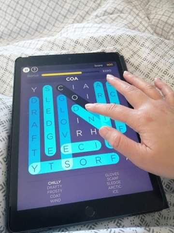 Photo d'une main jouant à un jeu d'entraînement cérébral sur une tablette tactile.