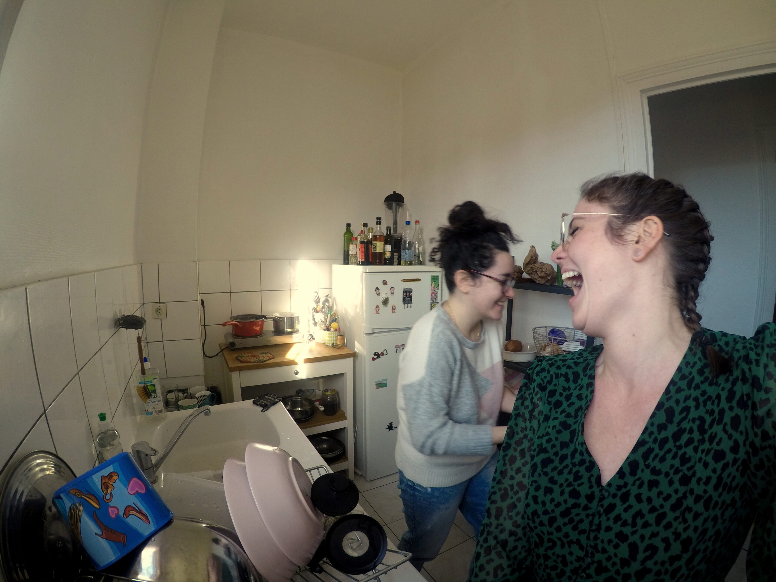 Nina est dans la cuisine avec sa colocataire Typhaine. Elles rigolent ensemble.