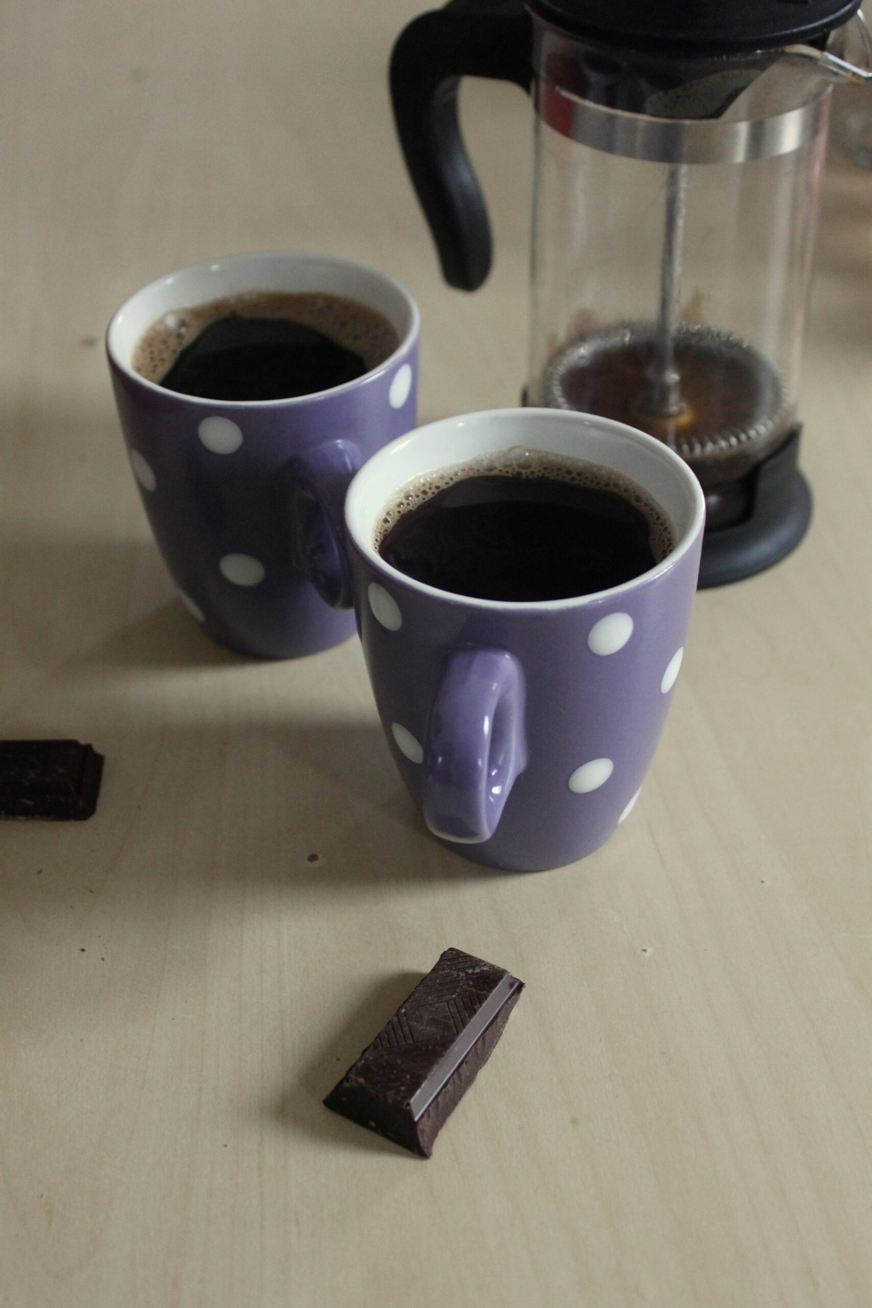 Une petite pause ! Photo zoomée de deux cafés et deux carrés de chocolat.