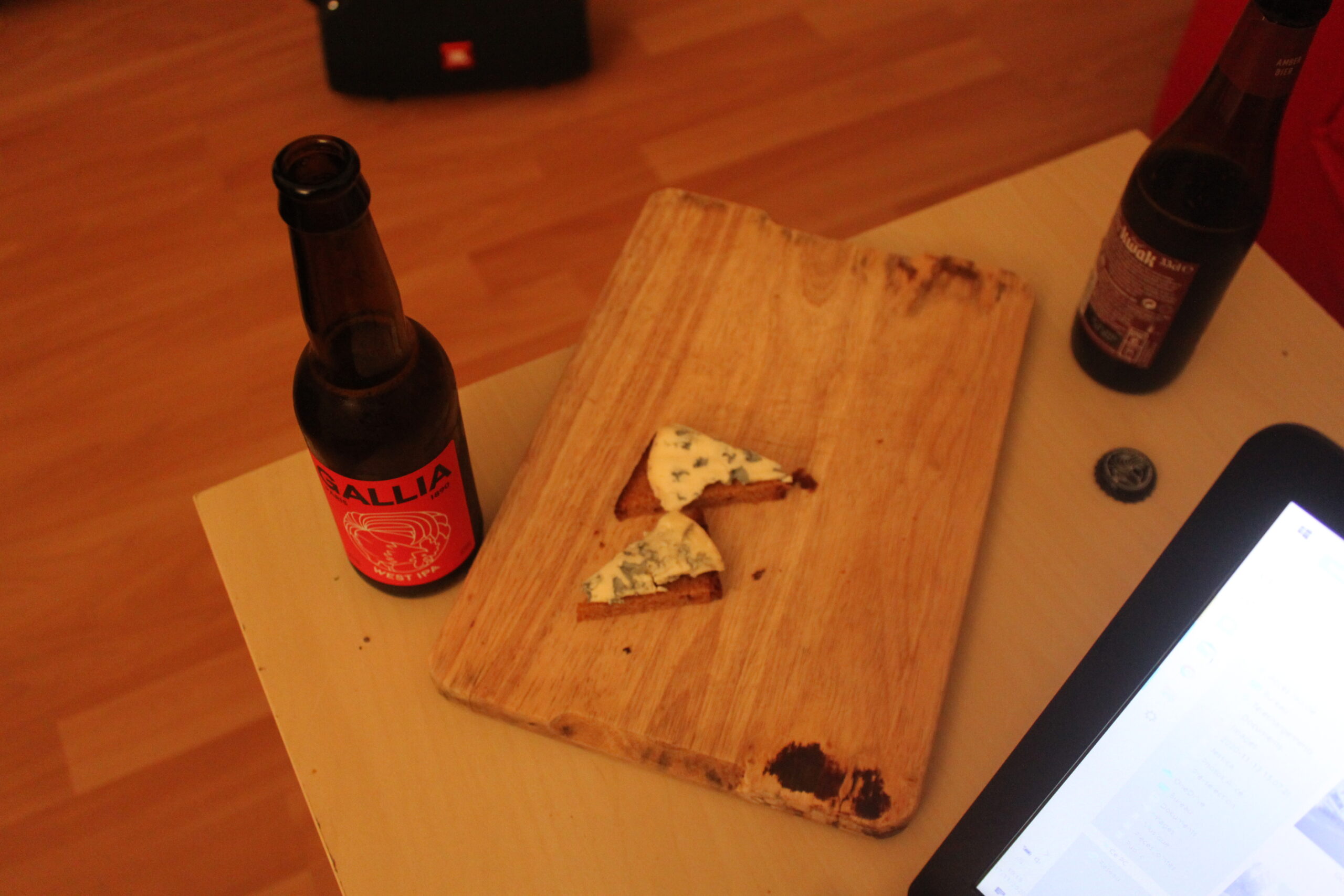 Fin de journée : sur un plateau il y a du fromage et à côté deux bières.