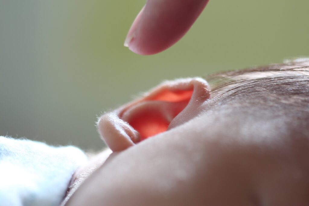 Un doigt désigne l'oreille d'un très jeune enfant.