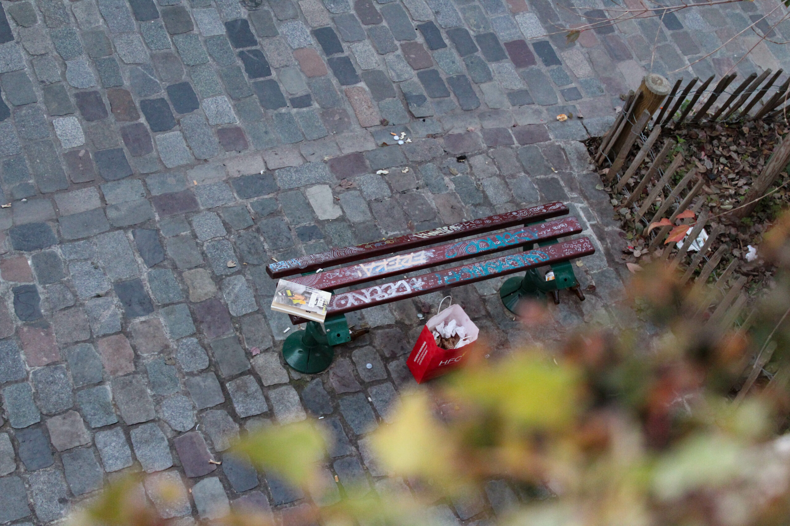 Banc rue Kléber (Bordeaux) avec graffitis et déchets laissés par des passant·es.